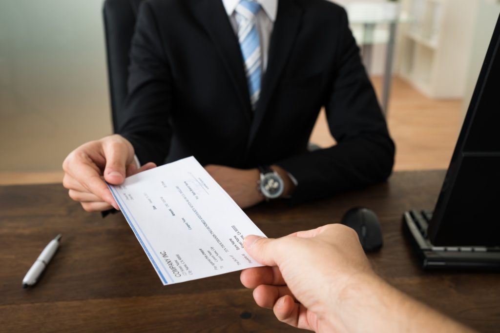 Person handing a check to a man