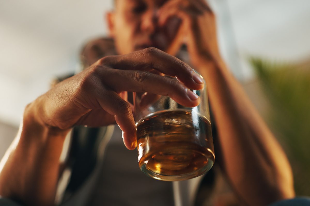 image of a man with an alcohol use disorder holding a glass of alcohol